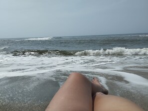 Escena de playa con olas y cielo despejado.