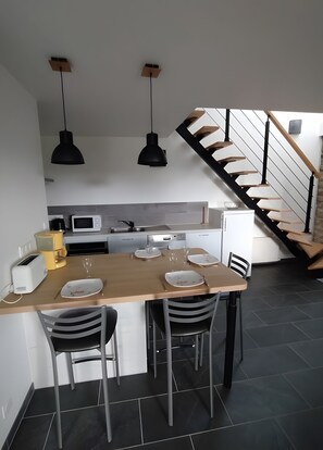 A modern kitchen with a dining area, a staircase, and a view of the living room. - Holiday home 'Le Gîte De Burguin' with private terrace, shared garden and Wi-Fi (Saint-Avé)