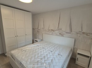 Ein Schlafzimmer mit einem Bett, einem Kleiderschrank und einem Nachttisch.