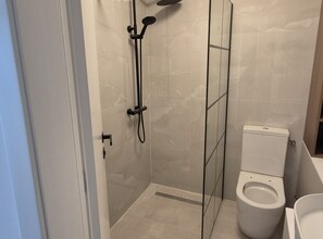 Ein Badezimmer mit Duschkabine, Toilette und Waschbecken.