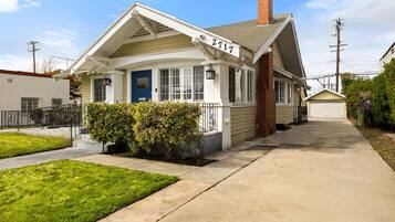 A single-story house with a front porch, a blue door, and a number '2717' on the side.