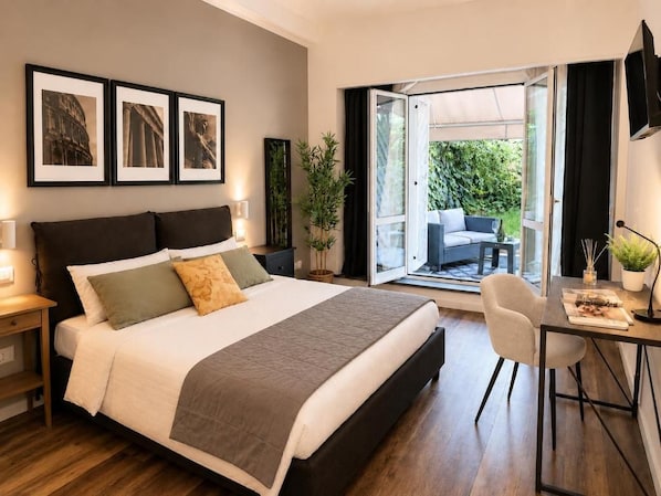 Quarto com cama, mesas de cabeceira, escrivaninha e vista para o exterior.