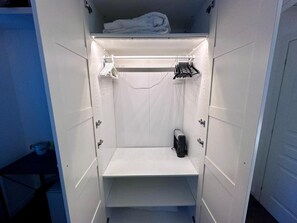 A small, enclosed space with a shelf, a towel rack, and a heater. - Garden Room by Casa Proto (Roma)