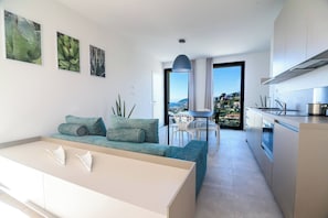 Eine moderne Wohnung mit einer Küchenzeile, einem Essbereich und einem Sofa.
