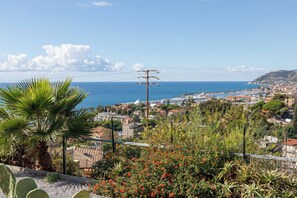 A coastal town with a marina, residential buildings, and a prominent church. - AGAVE POTATORUM APARTMENT - Vista mare (Sanremo)