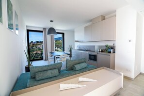 Un apartamento moderno con balcón, zona de comedor y kitchenette.