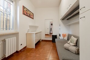 A compact living space with a kitchenette, a sofa with decorative pillows, and a wall-mounted artwork. - CASA CHRISTINE - Riva Ligure (Riva Ligure)