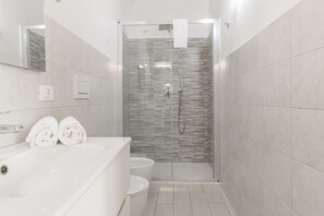 A modern bathroom with a glass-enclosed shower, a white bathtub, and a toilet. - ACQUAMARINA - Centro (Sanremo)
