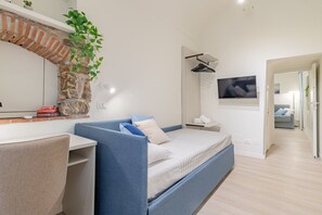 A modern bedroom with a bed, a desk, and a TV. - ACQUAMARINA - Centro (Sanremo)