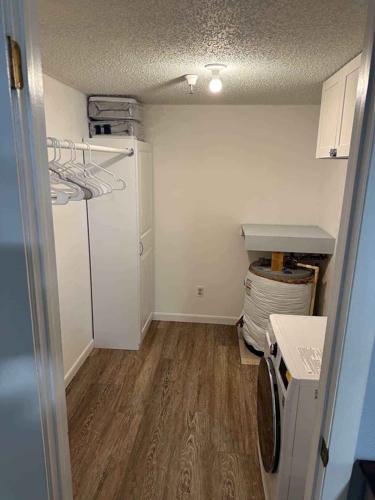 A laundry room with a washing machine, dryer, and a clothes drying rack.