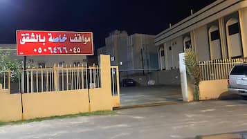 A gated entrance to a building with a sign in Arabic.
