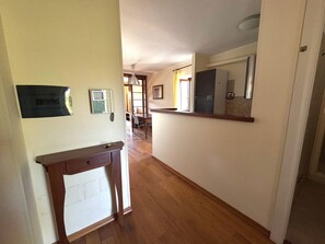 A hallway with a wooden floor, a desk with a telephone, a mirror, and a door leading to a room. - SUNSHINE - private parking - 3 min from the historic center - free Wi-Fi (Perugia)