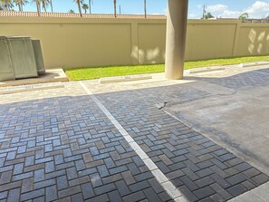 En asfalterad parkeringsplats med numrerade parkeringsrutor och en grön gräsmatta.