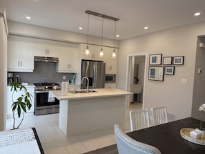 A modern kitchen with white cabinetry, stainless steel appliances, and pendant lighting. - Cambridge Parkside Oasis - 3Bed l 2.5 Bath l GYM l 4 Parking- Walk2 Smart Centre (Cambridge)