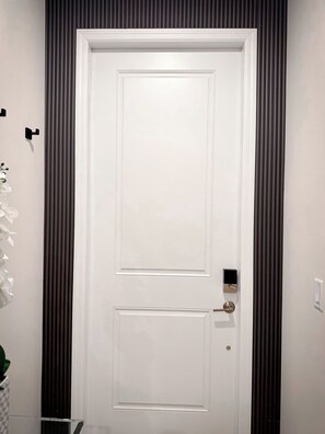A white door with a modern handle and a small electronic lock.