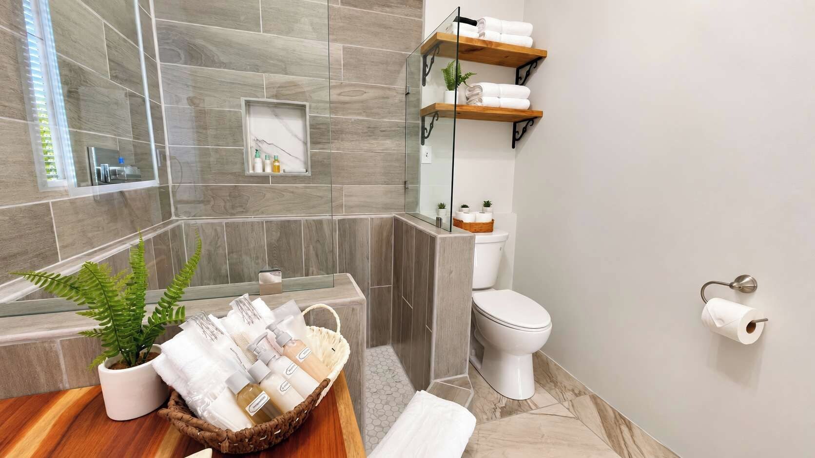 A bathroom with a bathtub, toilet, and a shelf with towels.