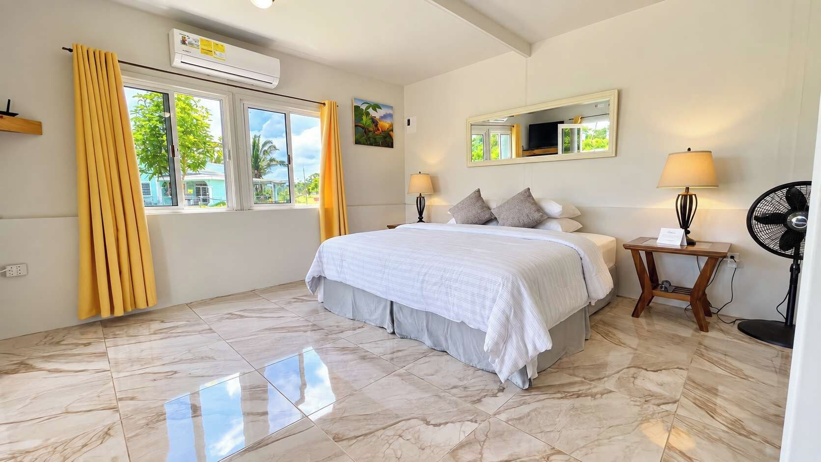A bedroom with a bed, bedside tables, a mirror, and a window with curtains.