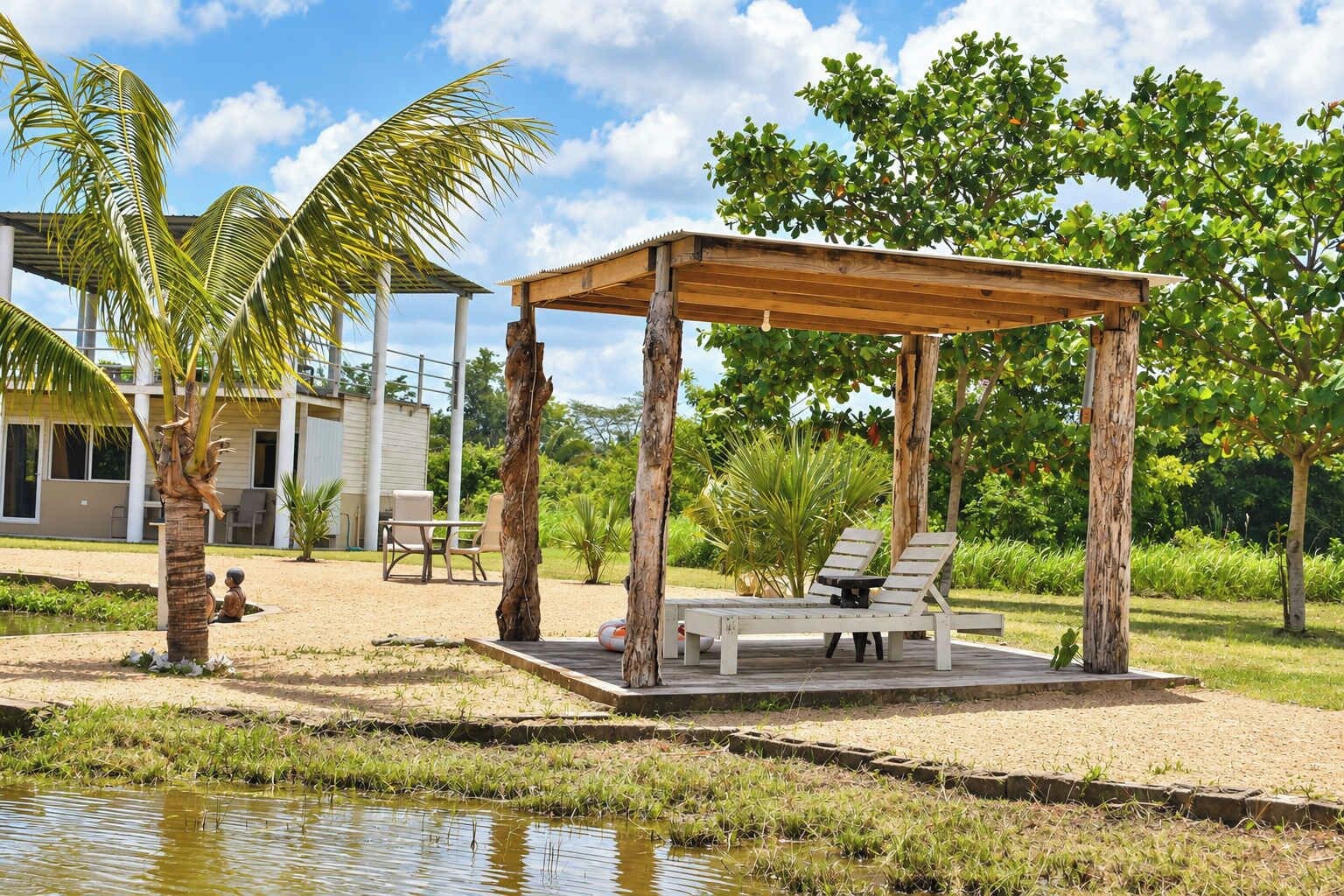 A wooden gazebo with two lounge chairs, a pool, and a building with a patio in the background.