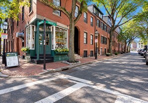 A street view of a brick building with a green awning and a sign for Mike & Patty's. - Charming 2BR Near Back Bay (Boston)