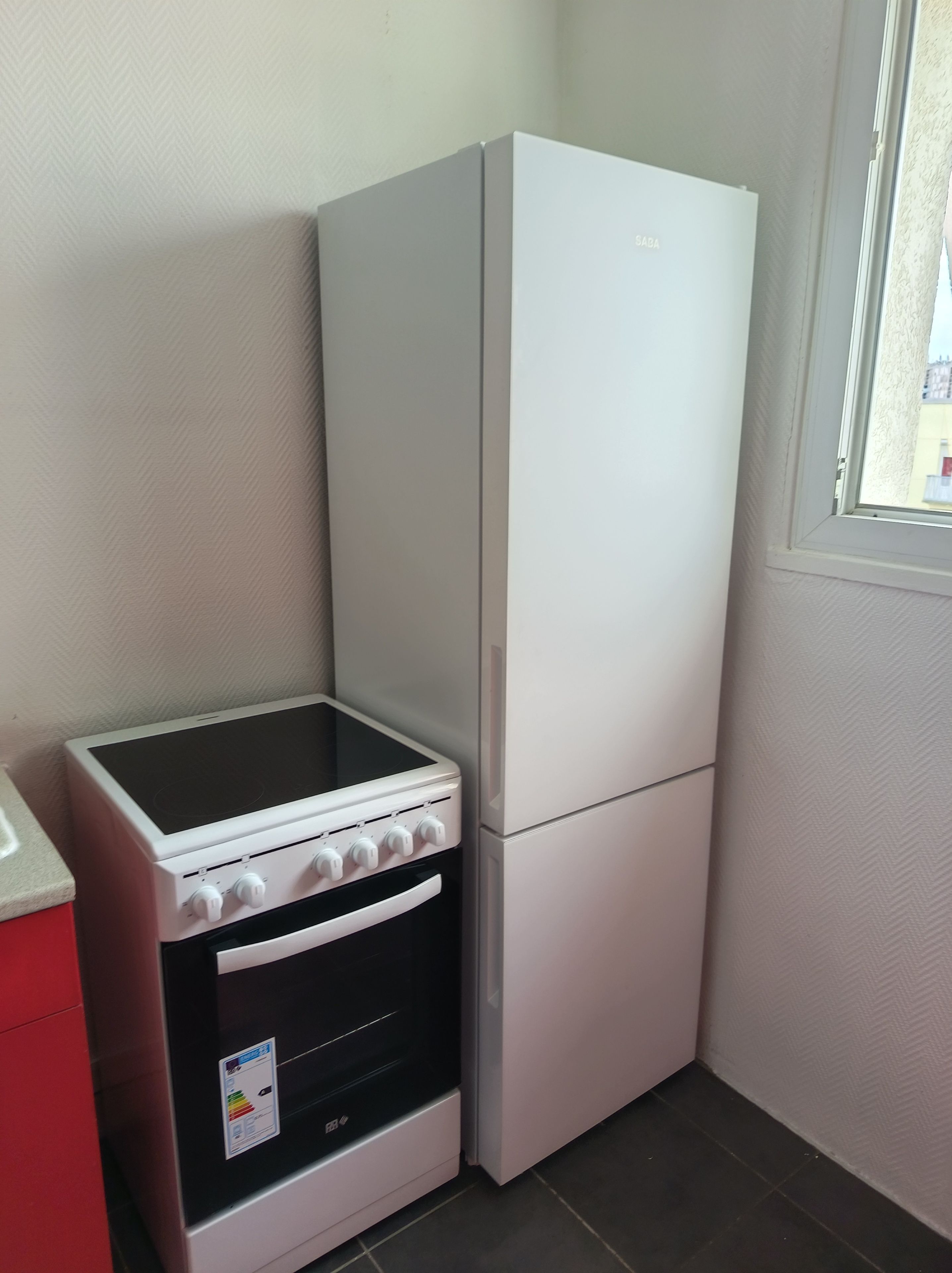 A compact kitchen with a built-in stove, oven, and a refrigerator.