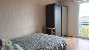 Une chambre à coucher avec un lit, une armoire et une fenêtre donnant sur un beau paysage.