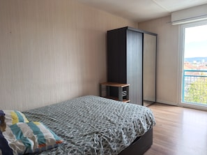 Une chambre à coucher avec un lit, une armoire et une fenêtre donnant sur un beau paysage.