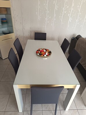 Une table à manger avec des chaises, un plat décoratif et un buffet rempli de vaisselle.