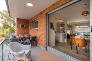 Covered outdoor seating with direct access from the living space, perfect for enjoying Manly’s leafy surrounds - Manly 2BR | 5 Min Walk to Beach + Parking (Manly)