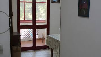A room with a sliding glass door leading to an outdoor area with a wooden table and chairs.