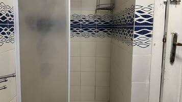 Ein Badezimmer mit weißen Fliesen und blauen Dekormustern.