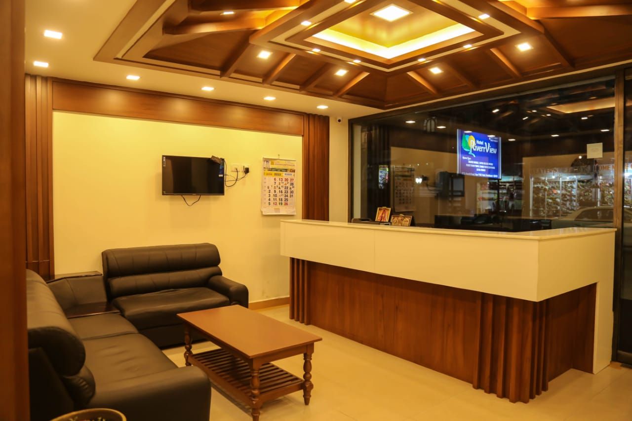 A reception area with a reception desk, a flat-screen TV, a sofa, and a coffee table.