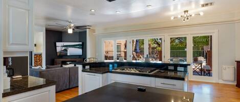 A modern kitchen with a central island, built-in appliances, and a view to an outdoor patio area.