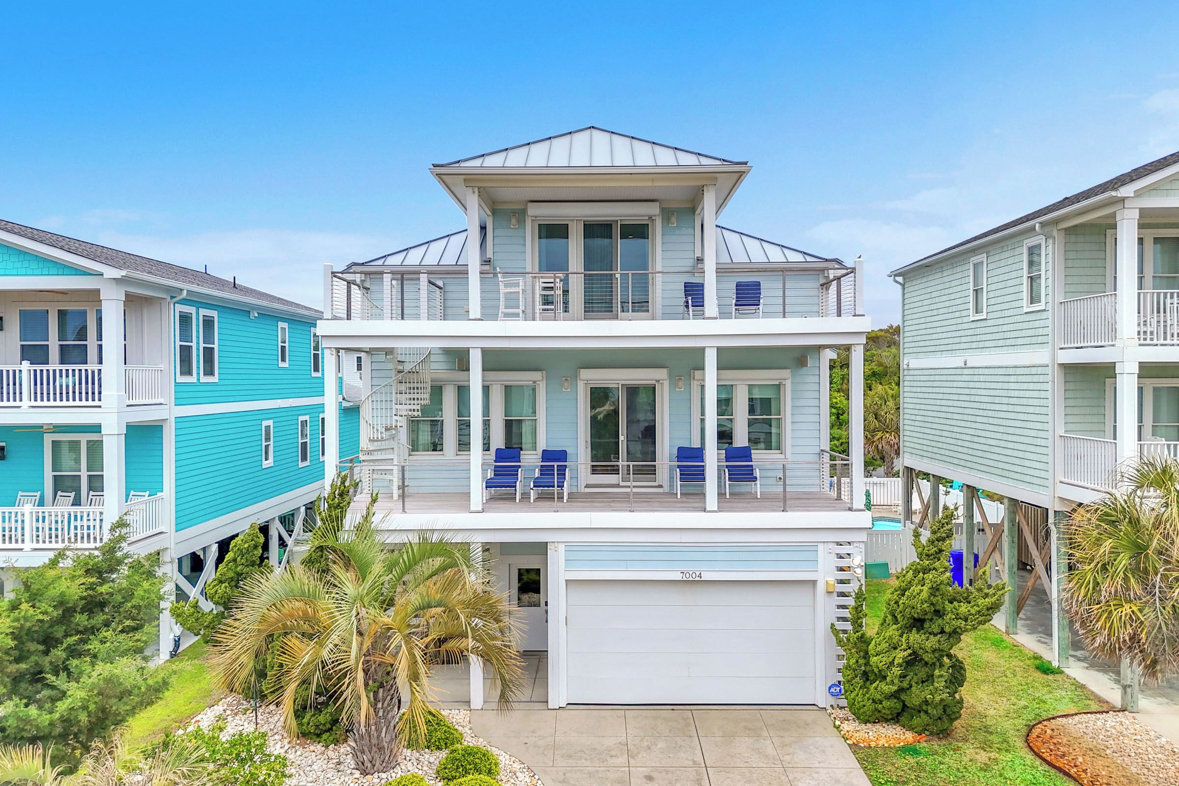 Ein zweigeschossiges Wohnhaus mit Balkon, Garage und Schwimmbad.