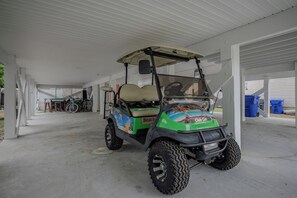 Ein überdachter Parkbereich mit einem Golfwagen darin.