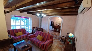 A cozy living room with striped sofas, a coffee table, and a chandelier. - VILLA WITH PRIVATE POOL IN SANLUCAR DE BARRAMEDA - VILLA MI DESEO (Sanlúcar de Barrameda)