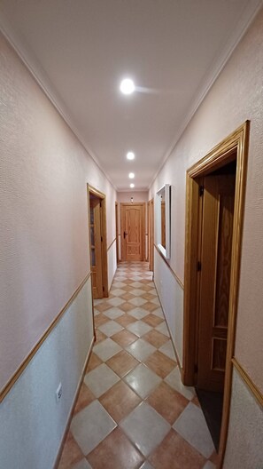 A hallway with checkered flooring, wooden doors, and recessed ceiling lighting. - VILLA WITH PRIVATE POOL IN SANLUCAR DE BARRAMEDA - VILLA MI DESEO (Sanlúcar de Barrameda)
