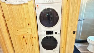 A laundry room with a wooden door labeled 'LAUNDRY' and a front-loading washing machine.