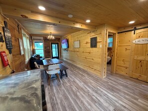 A wooden interior with a dining area, a kitchen, and a laundry room.
