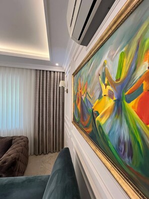 A room with a large abstract painting, a sofa, and a window with curtains. - Luxury 4-Bedroom Villa with Private Saltwater Pool in Dalyan (Muğla)