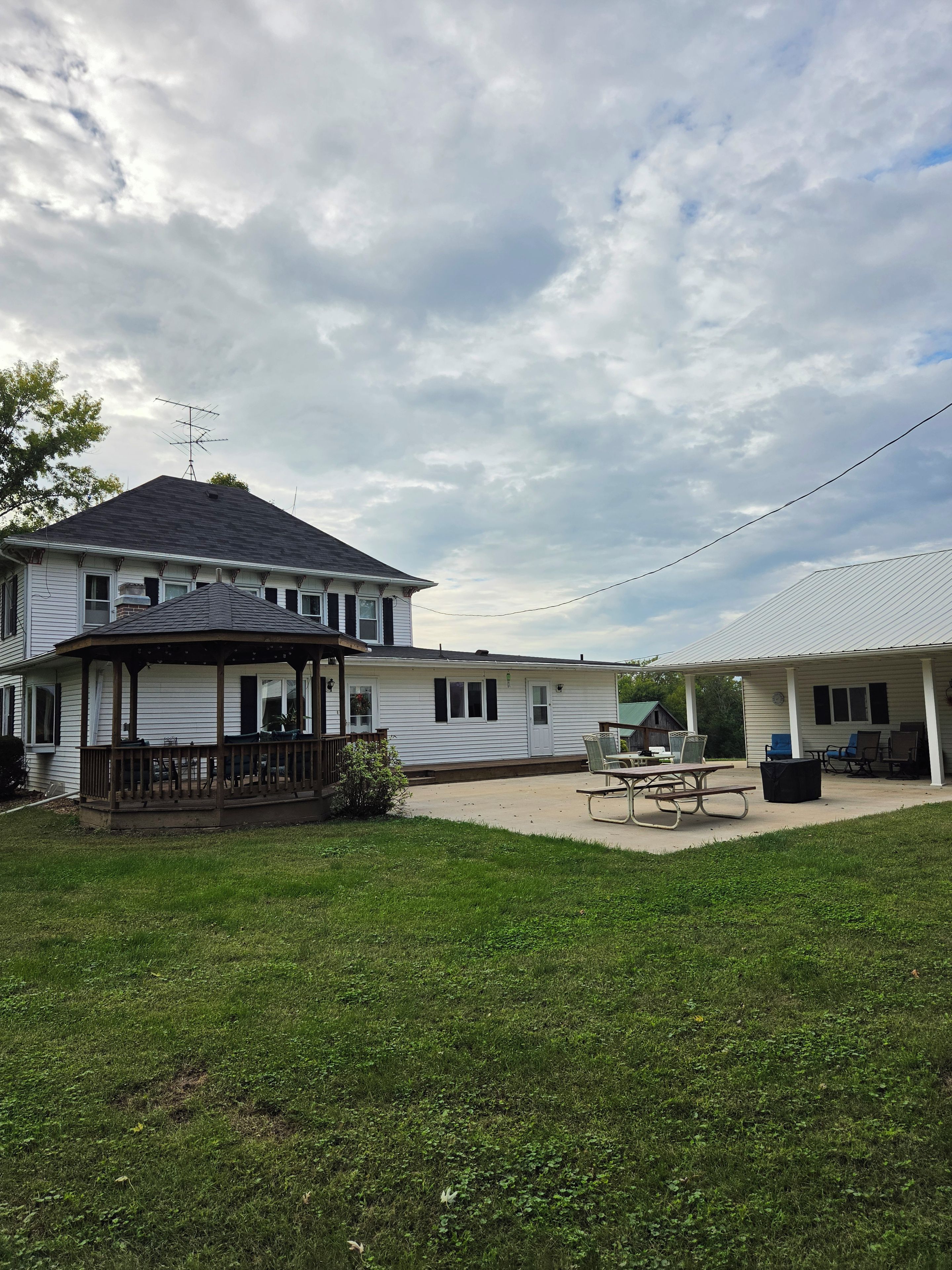 A two-story building with a covered porch and a patio area.