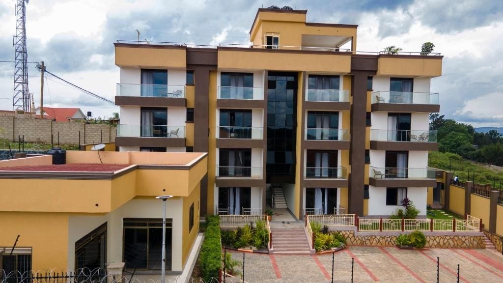 A multi-story residential building with balconies, a central staircase, and a landscaped courtyard.