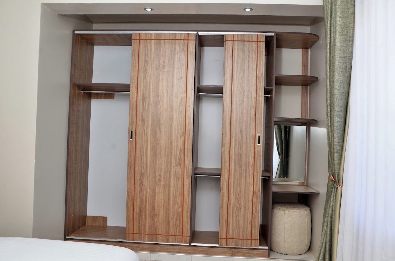 A wardrobe with sliding doors and multiple shelves.