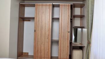 A wardrobe with sliding doors and multiple shelves.