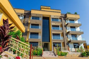 Un edificio de varios pisos con una escalera central, balcones y techo plano.