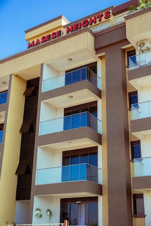 Un edificio de varios pisos con un letrero que dice 'MASESE HEIGHTS'.
