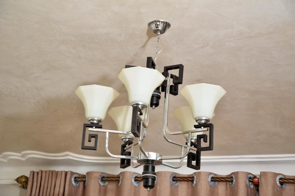 Un candelabro colgado del techo con múltiples brazos e iluminaciones.