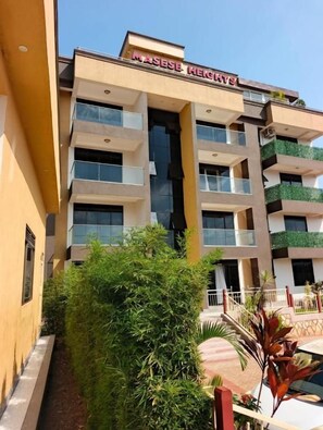 A multi-story hotel with balconies and a central entrance.
