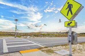 A pedestrian crossing with a warning sign, a directional arrow sign, and a push button for lights. - Beach View Perdido Key;  Beach Views, Heated Pool, Spa & Firepit (Pensacola)