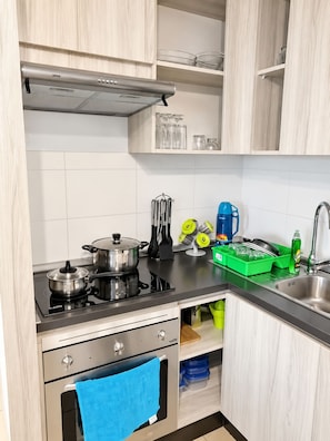A kitchen with a stove, oven, and various kitchen utensils. - Acogedor Depto a una Cuadra del Mar (Coquimbo)