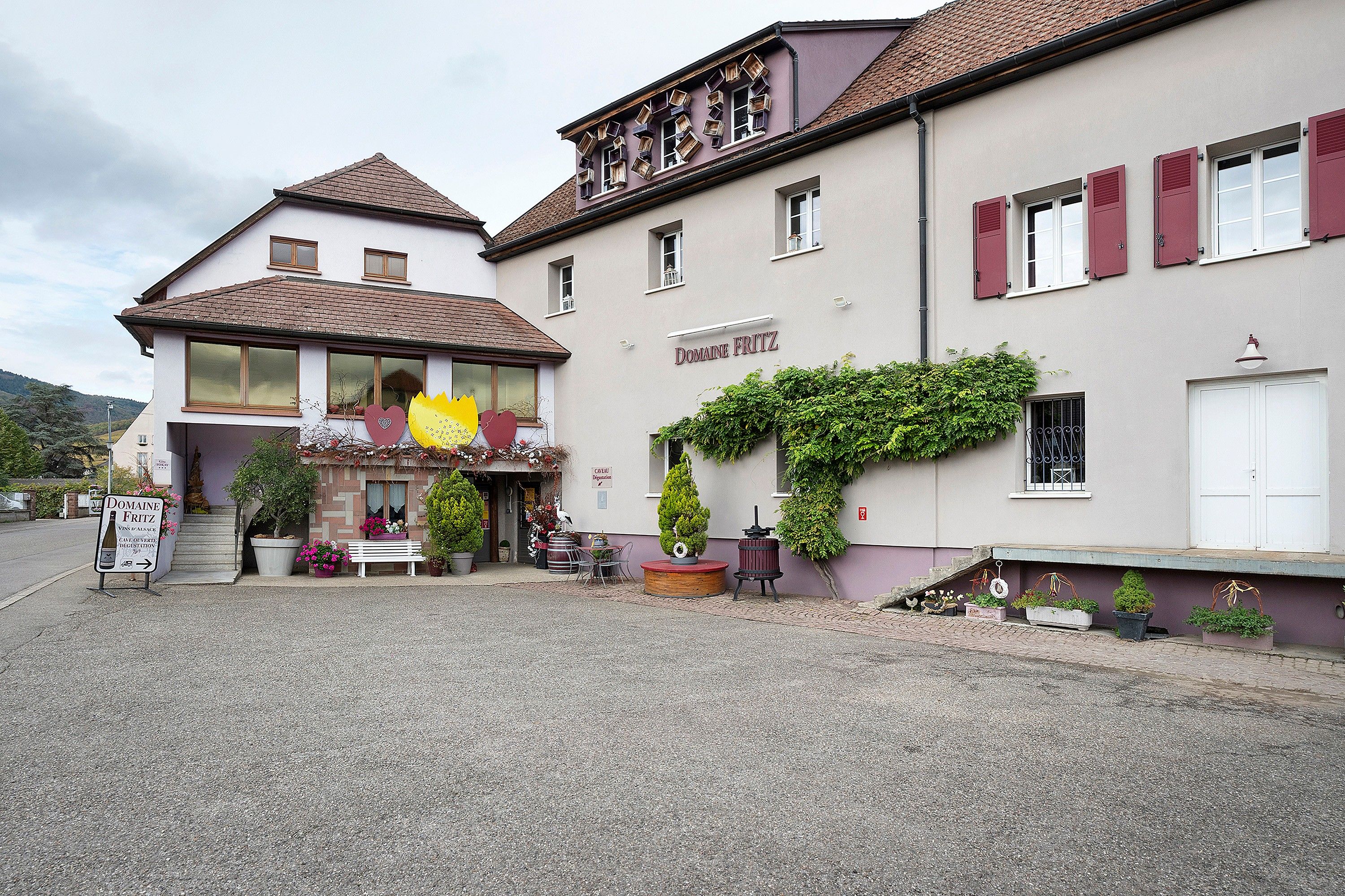 A two-story building with a sign for Domaine Fritz, featuring a café and a wine cellar.